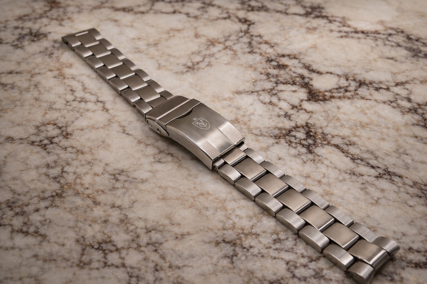 Super-O Boyer stainless steel watch bracelet featuring solid three-link brushed finish and engraved clasp, premium sport-style metal watch strap.